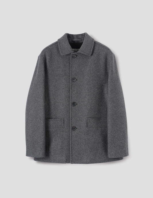 Charcoal grey wool coat with with deep relaxed welt pockets and stitch through detailing. Finished with horn button closure. Front flat lay view. 