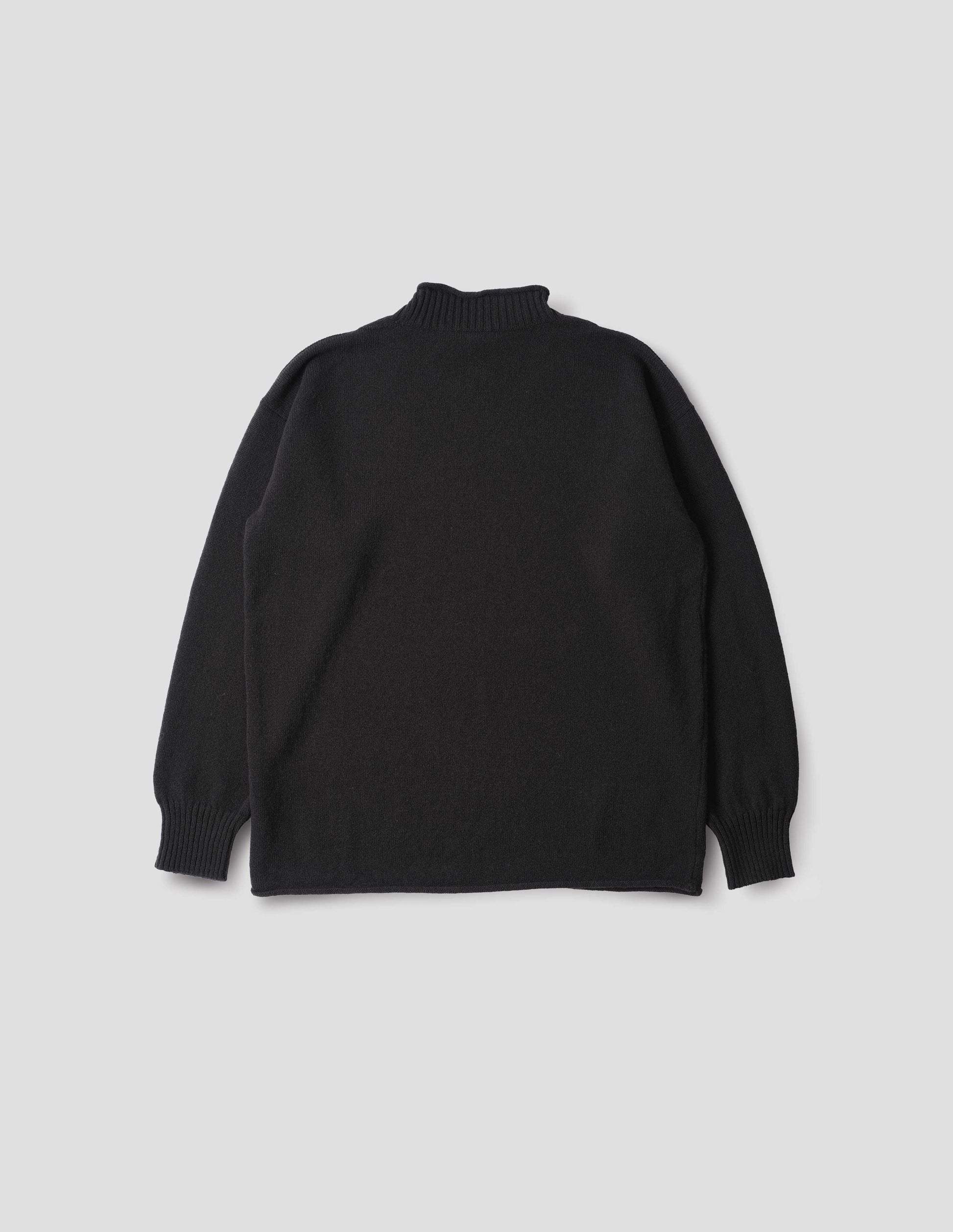 Black long sleeve jumper with rolled edge neck and hem and contrasting rib on neck and sleeves. Back flat lay view.