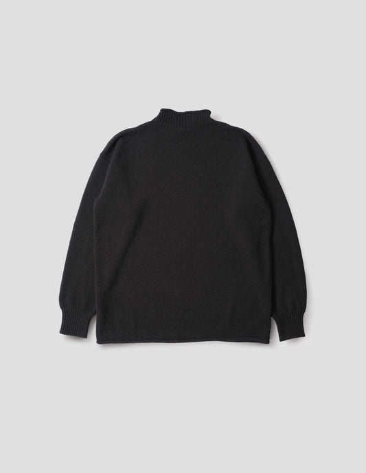 Black long sleeve jumper with rolled edge neck and hem and contrasting rib on neck and sleeves. Back flat lay view.
