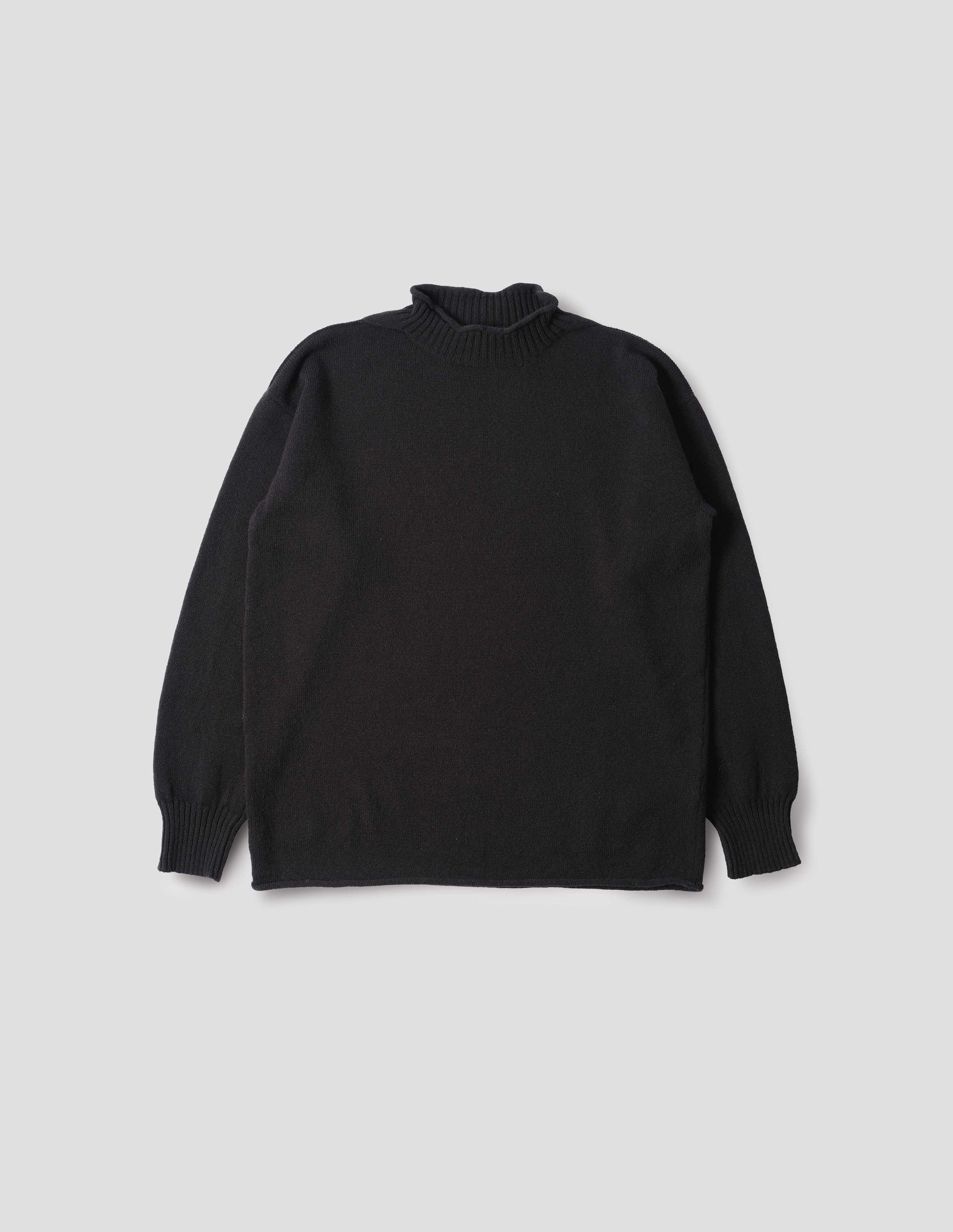 Black long sleeve jumper with rolled edge neck and hem and contrasting rib on neck and sleeves. Front flat lay view.