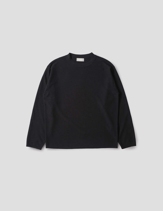 Black crew neck jumper with rolled edge detailing on neck, rib trim on cuffs and hem. Front flat lay view.