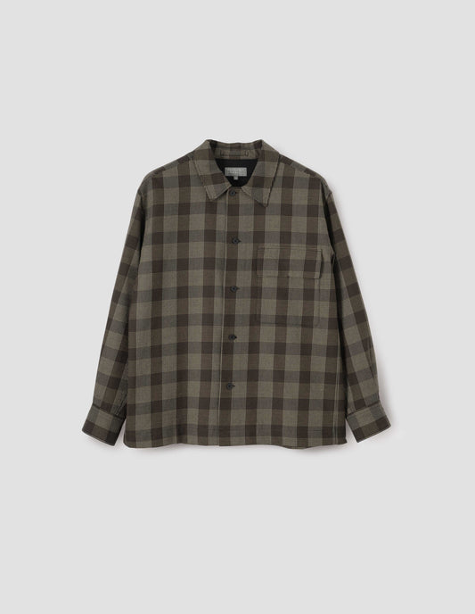 Black, brown and green checked wool shirt, with horn button fastening, deep placket and flap patch pocket. Front flat lay view.