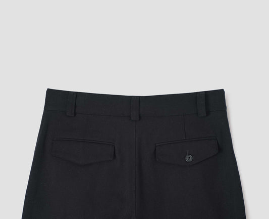 Black heavy cotton trousers, with belt loops and concealed and button-through jet back pockets, back flat lay view.