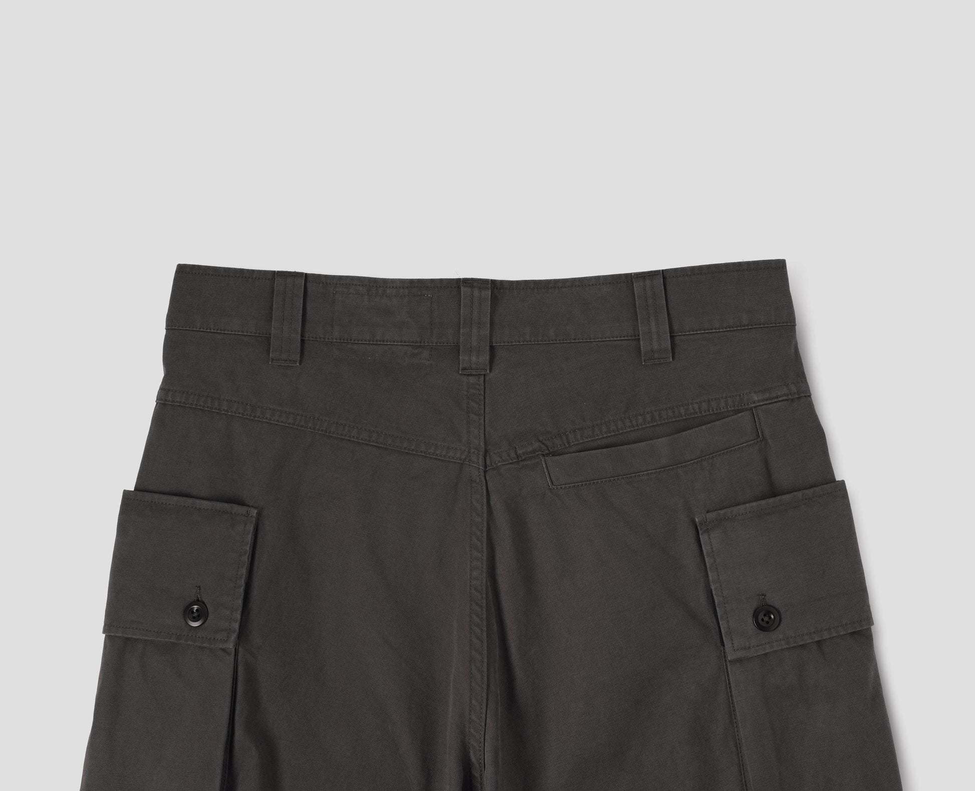 Brown cargo trousers with deep flap button fastening patch pocket, belt loops and welt pocket on back yoke. Back flat lay view.