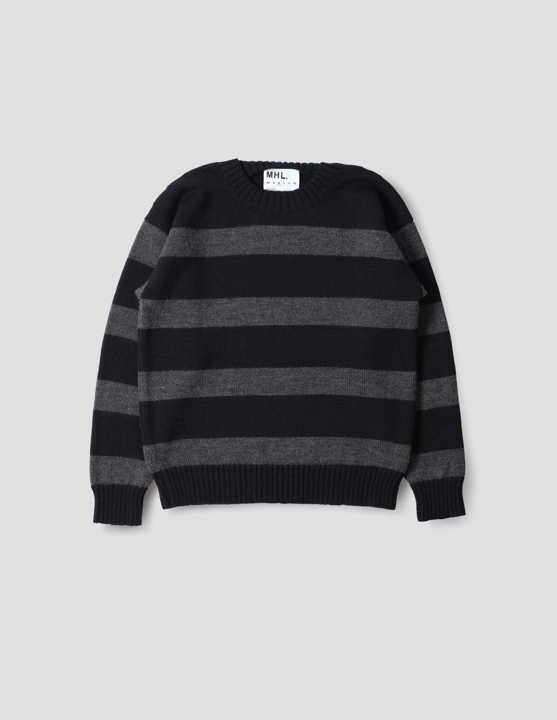 Black and grey striped wool jumper, with ribbed neck, cuffs and hem. Front flat lay view. 