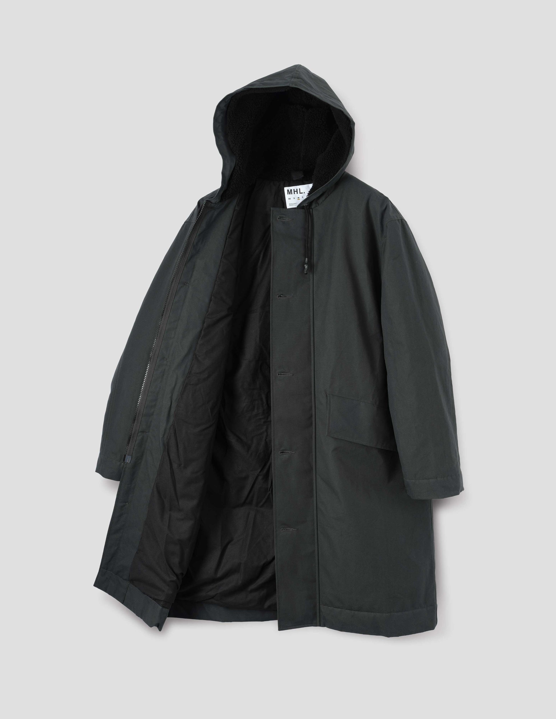 Blueish green hooded parka with fleece lined drawcord hood, two way zip fastening with button fastening storm flap and slanted flap pockets. Front flat lay open view.