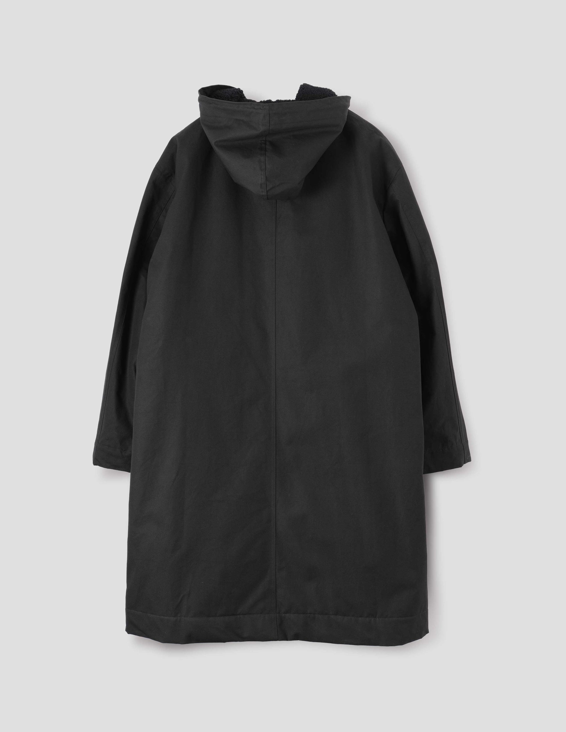 Black hooded parka with fleece lined drawcord hood. Back flat lay open view.