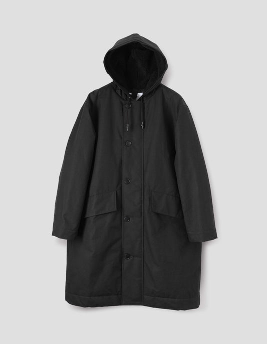 Black hooded parka with fleece lined drawcord hood, two way zip fastening with button fastening storm flap and slanted flap pockets. Front flat lay view.
