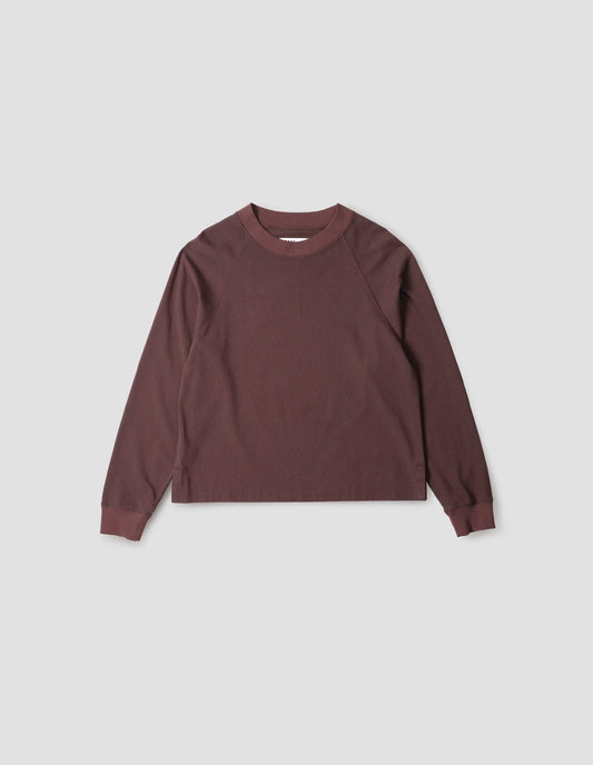 Reddish purple long sleeve t-shirt with raglan sleeve, single rib trims on neck and cuffs and vent split hem. Front flat lay view.