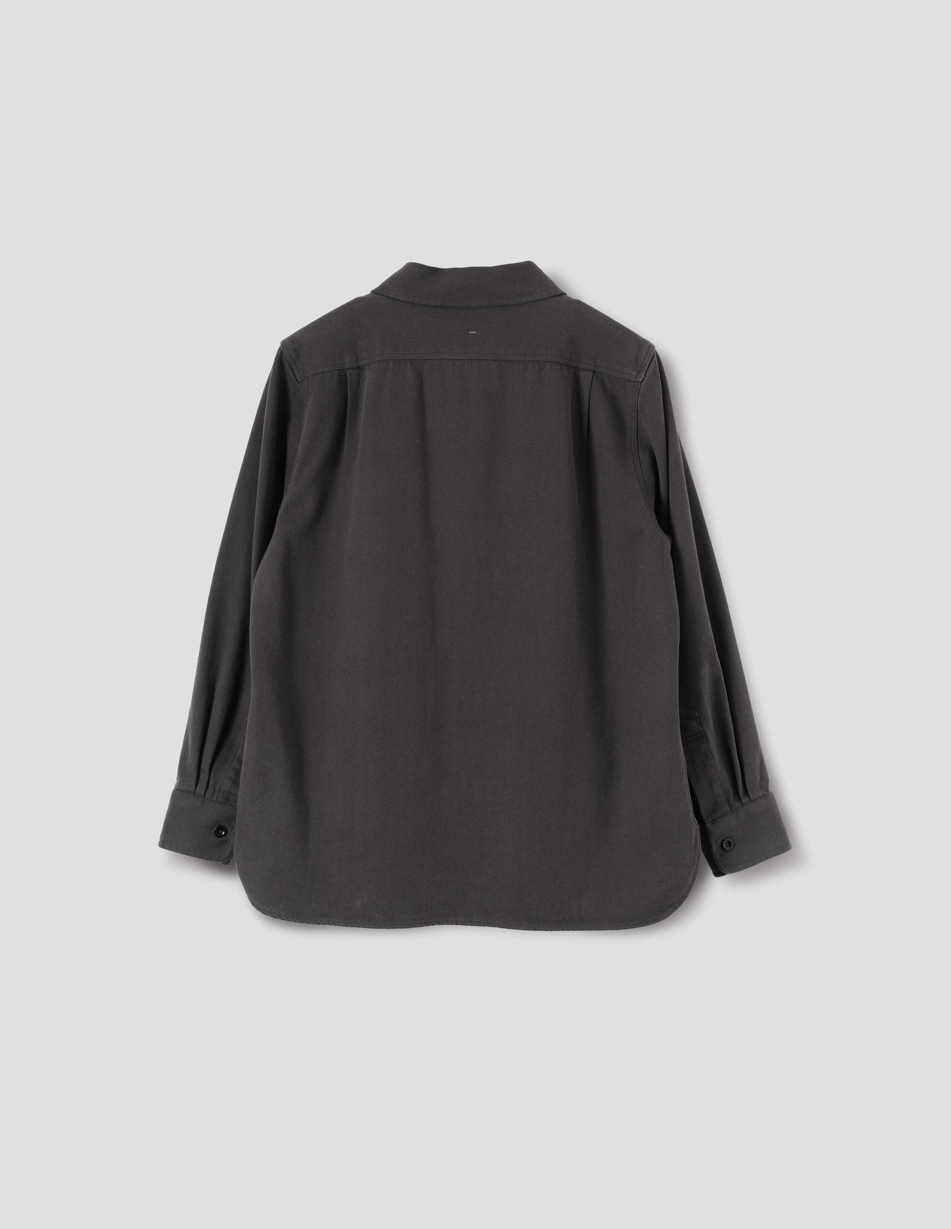 Grey overhead shirt with corozo button closure cuffs and elongated back hem. Back flat lay view.