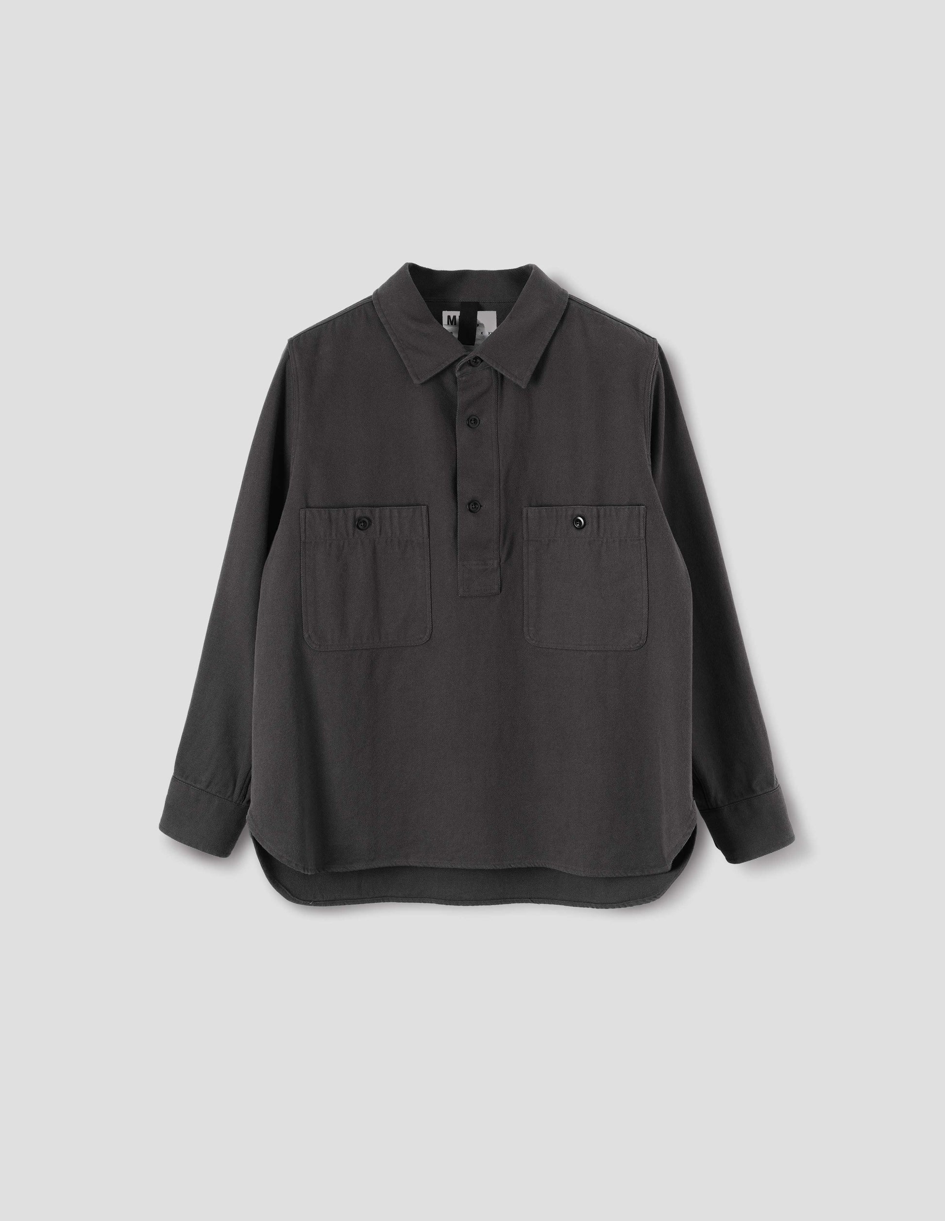 Grey overhead shirt with raised placket, box stitch detailing, button through chest patch pockets and elongated back hem. Front flat lay view.