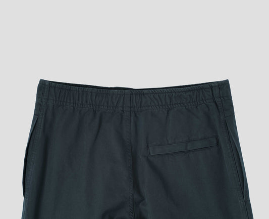 Blue trousers with slant welt pockets and press stud hem adjusters. Back flat lay view.