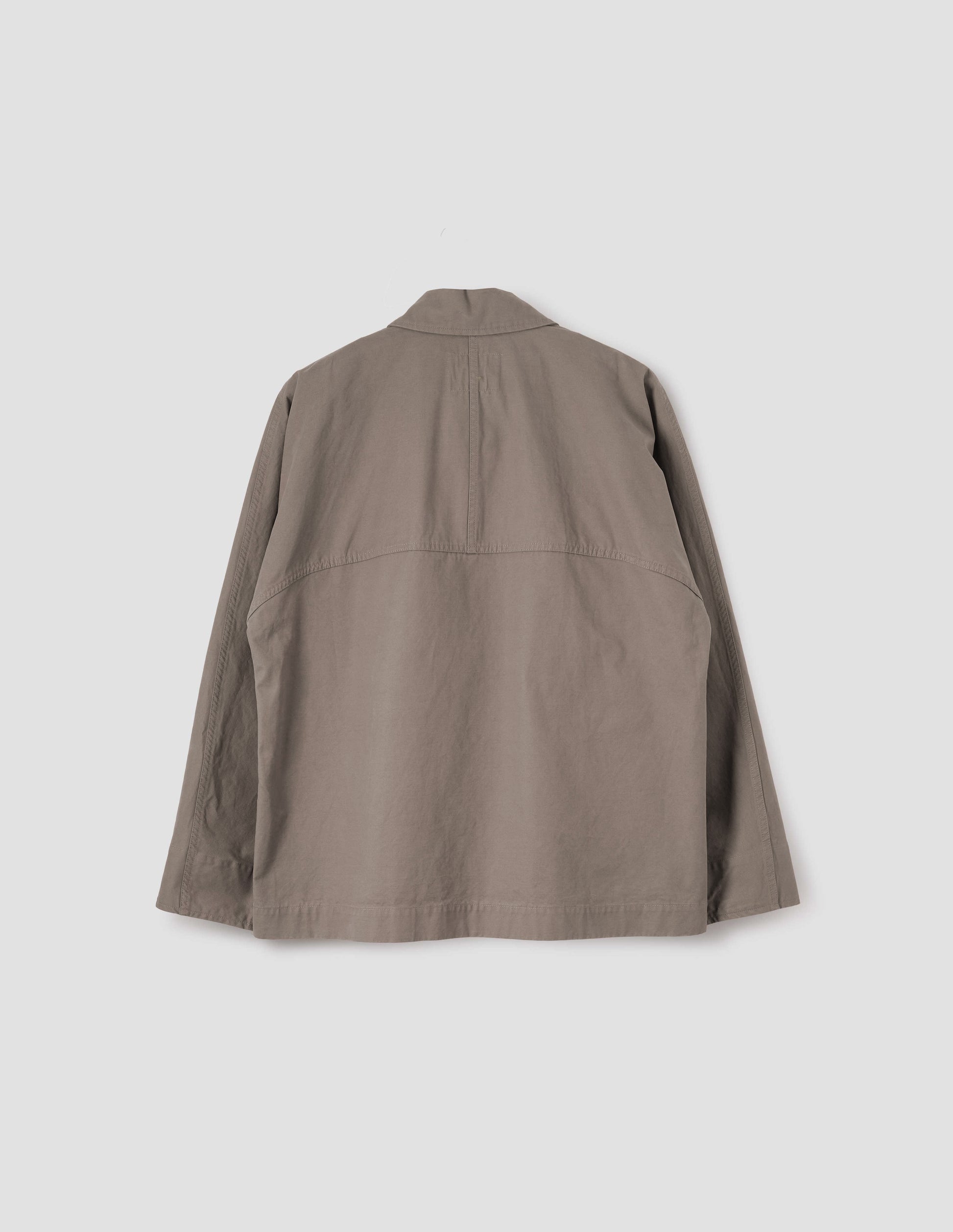 Beige raglan sleeve jacket with split panel detailing on back yoke, back flat lay view.