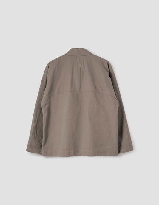 Beige raglan sleeve jacket with split panel detailing on back yoke, back flat lay view.