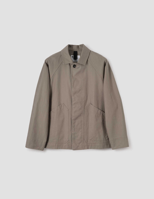 Beige raglan sleeve jacket with corozo button fastening fly front and slant patch pockets, front flat lay view.