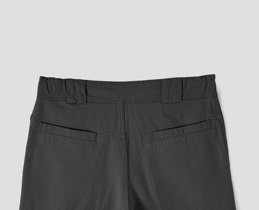 Grey trousers with side elasticated waistband, wide belt loops and stitch through welt back pockets on back yoke. Back flat lay view. 