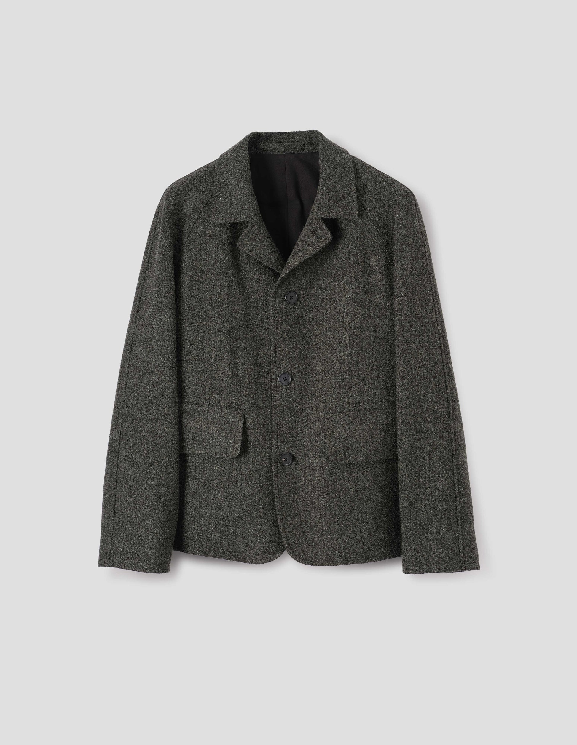 Dark grey harris tweed wool blazer with high collar fastening, deep flap welt pockets and subtle horn button detailing. Front flat lay view.
