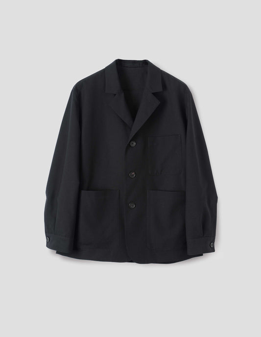Black wool blazer with horn button fastening, deep wrap closure, shirt cuff sleeves and patch pockets. Front flat lay view.