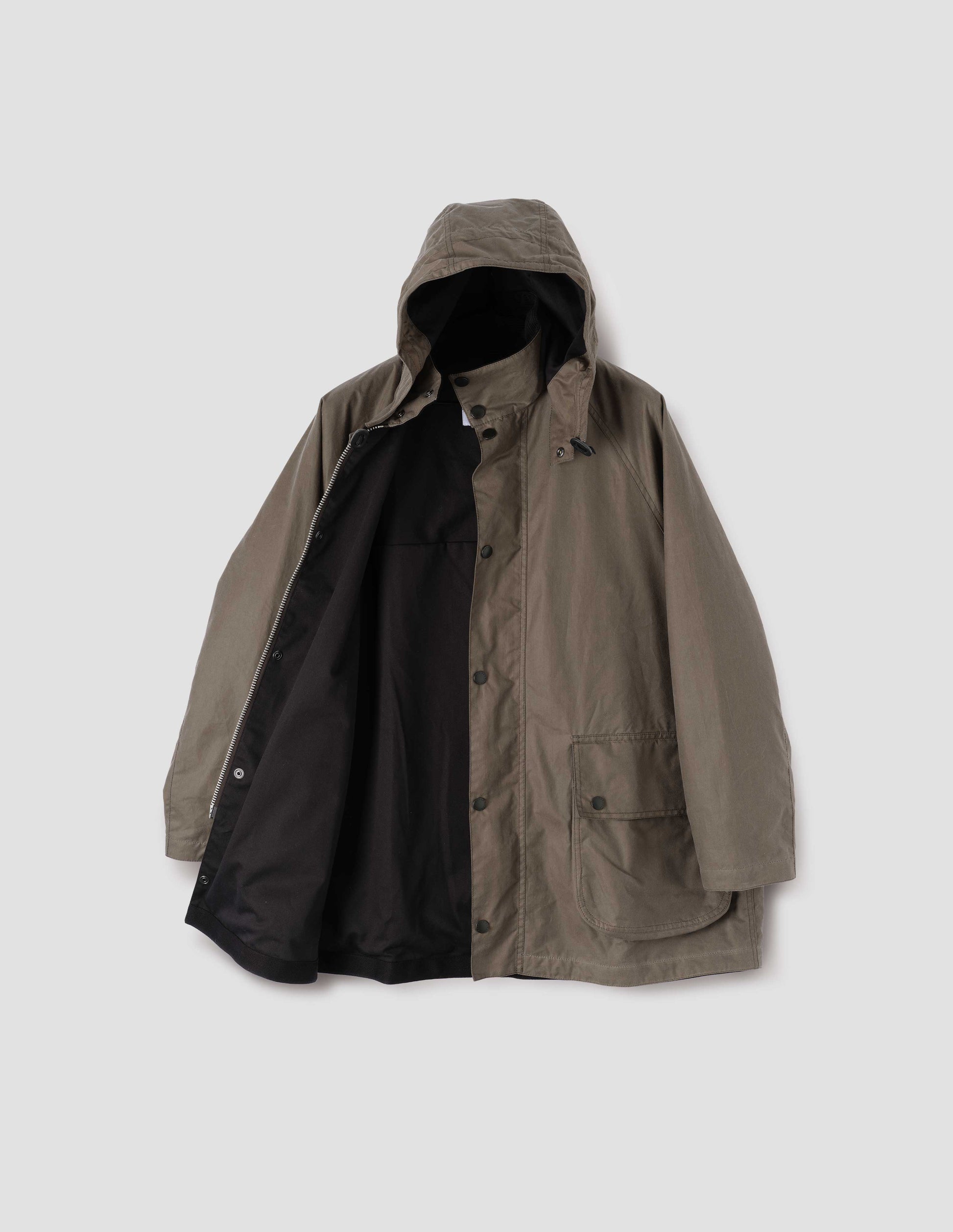 Dark beige cotton drill lined parka with stand collar and hood with wire adjustable peak, raglan sleeve, two way zip fastening, press stud fastening storm flap and large bellows pockets with press stud fastening envelope closure. Open flat lay view.