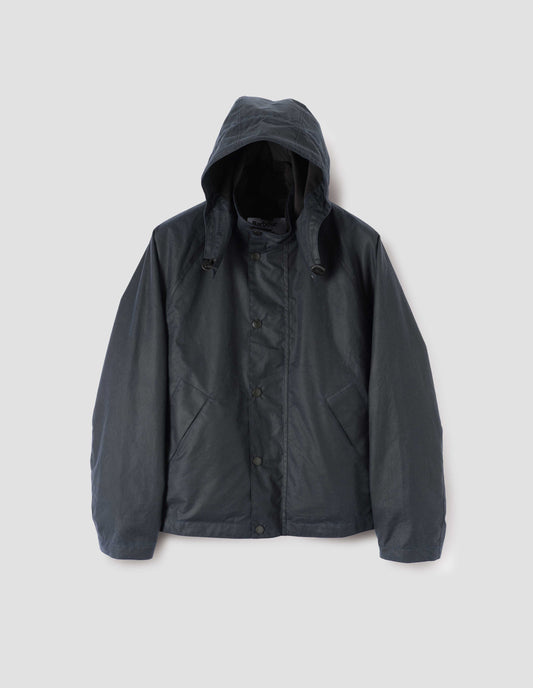 Dark blue boxy jacket with stand collar and hood with wire adjustable peak, raglan sleeve, press stud storm flap and wide storm welt side pockets. Front flat lay view.