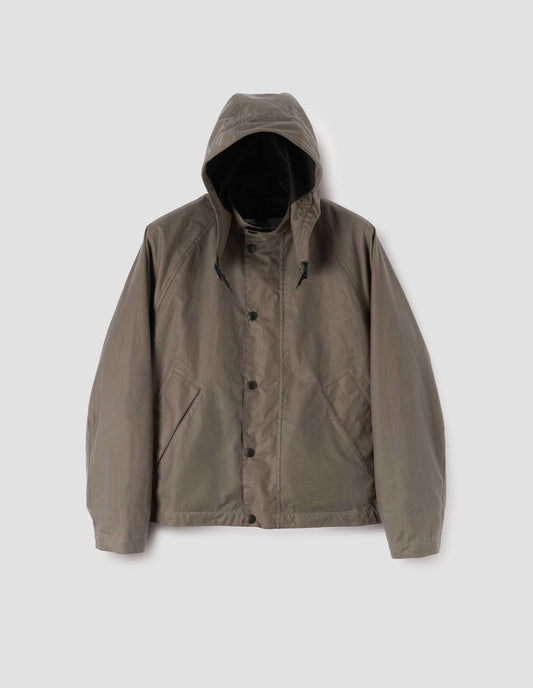 Dark beige cotton drill lined boxy jacket with stand collar and hood with wire adjustable peak, raglan sleeve, press stud storm flap and wide storm welt side pockets. Front flat lay view.