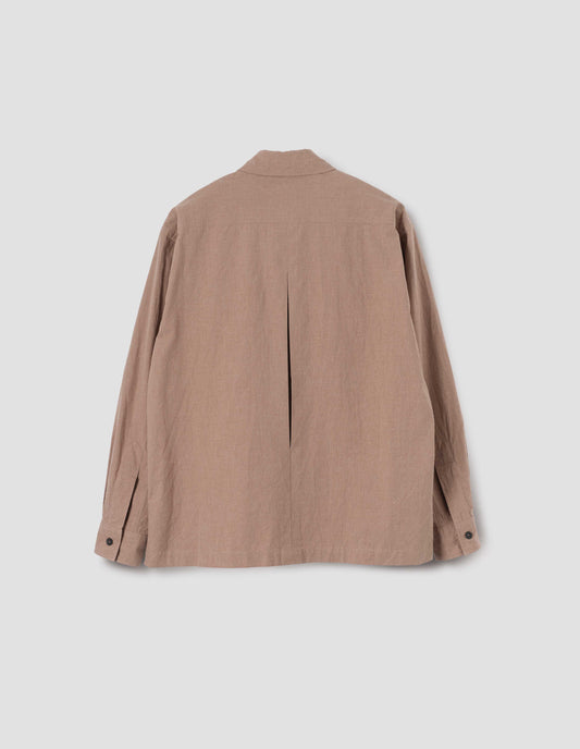 Light brown shirt with vent split hem, deep inverted pleat on back yoke and horn buttons on cuffs, back flat lay view.
