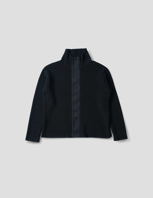 Black zip through wool cardigan with stand collar, straight hem and cuffs and contrast cotton tape placket with chunky Vislon zip fastening. Front flat lay view.