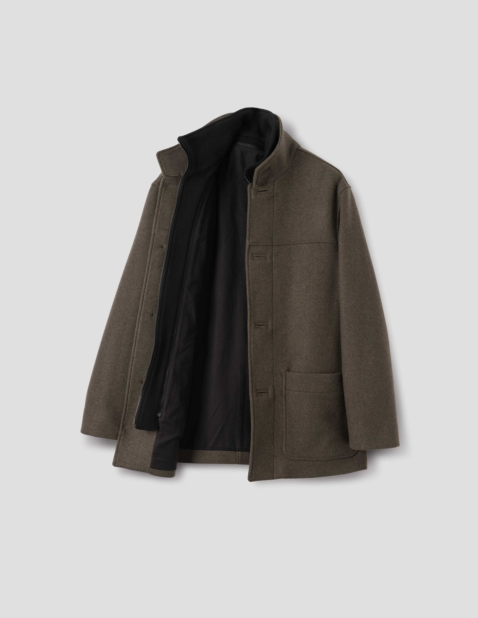 Khaki green wool coat with internal funnel collar and external half mock collar, detachable fleece facing with invisible nylon coil zip, zip front closure, front yoke, jetted buttonholes and patch pockets. Open flat lay view.