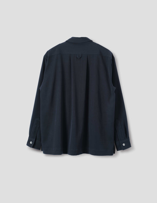Dark blue wool shirt with mother of pearl buttons on cuffs, wide box pleat and hanger loop detail on back yoke. Back flat lay view.