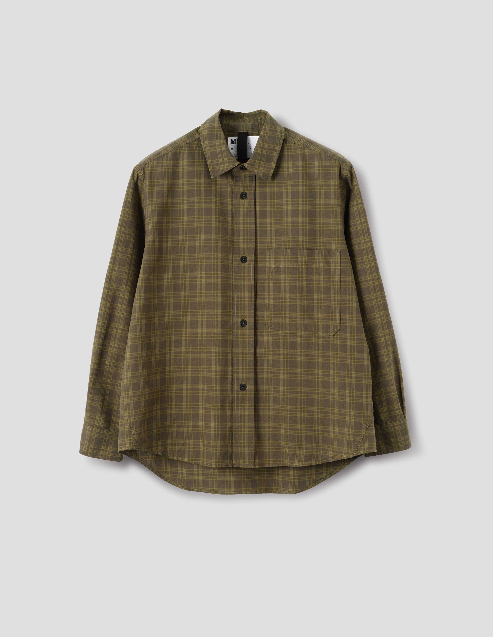 A relaxed green tonal check cotton shirt with a raised placket, large chest pocket, side gusset stitch detailing and hanger loop detailing on inside collar. Curved hem. Front flat lay view.