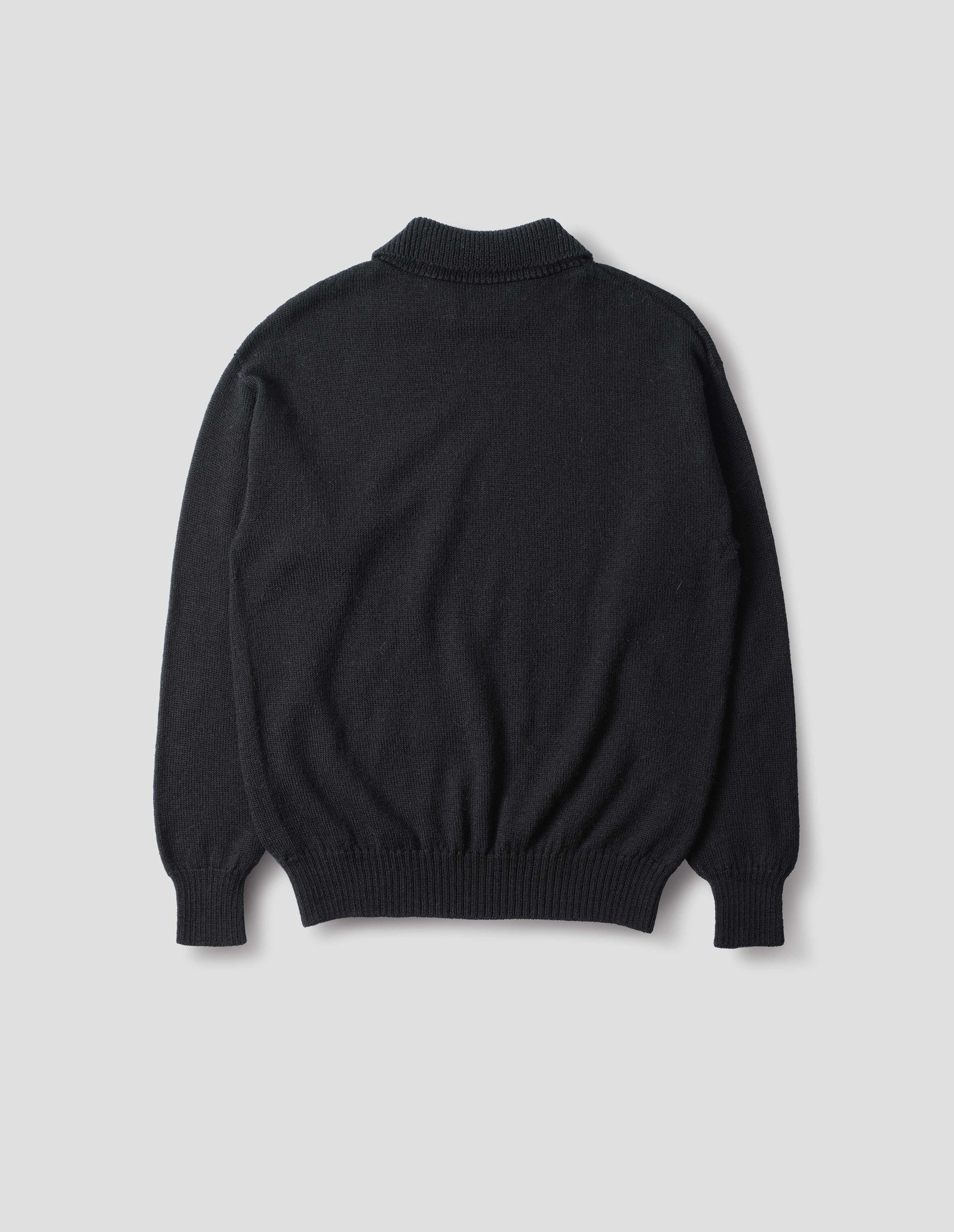 Collared wool sweater in black with a wide rib linked on collar, plain knit body, and deeper ribbed cuffs. Finished with a straight hem, back flat view.
