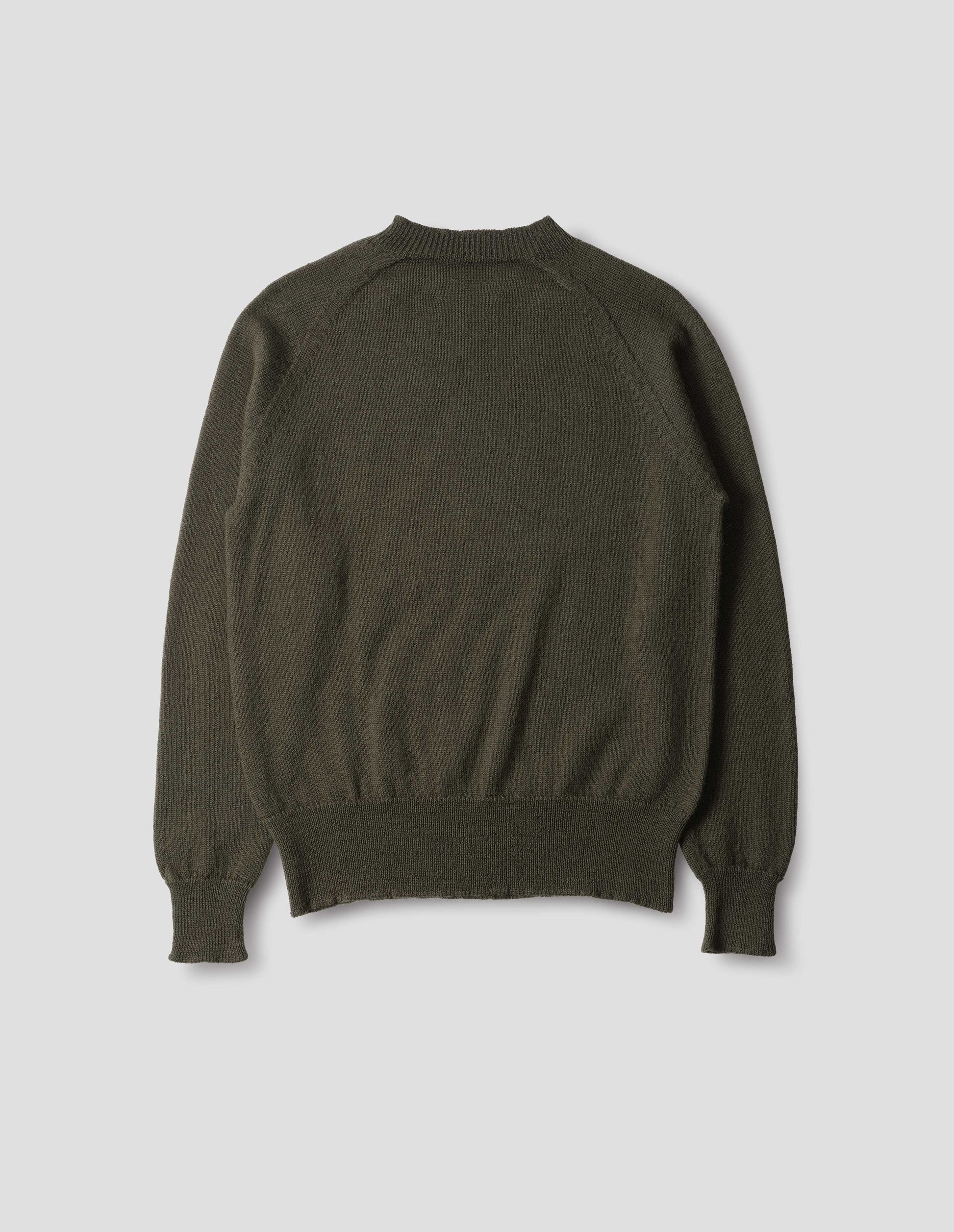 Dark green wool jumper, with raglan sleeve, rib collar, cuffs and hem, back flat lay view.