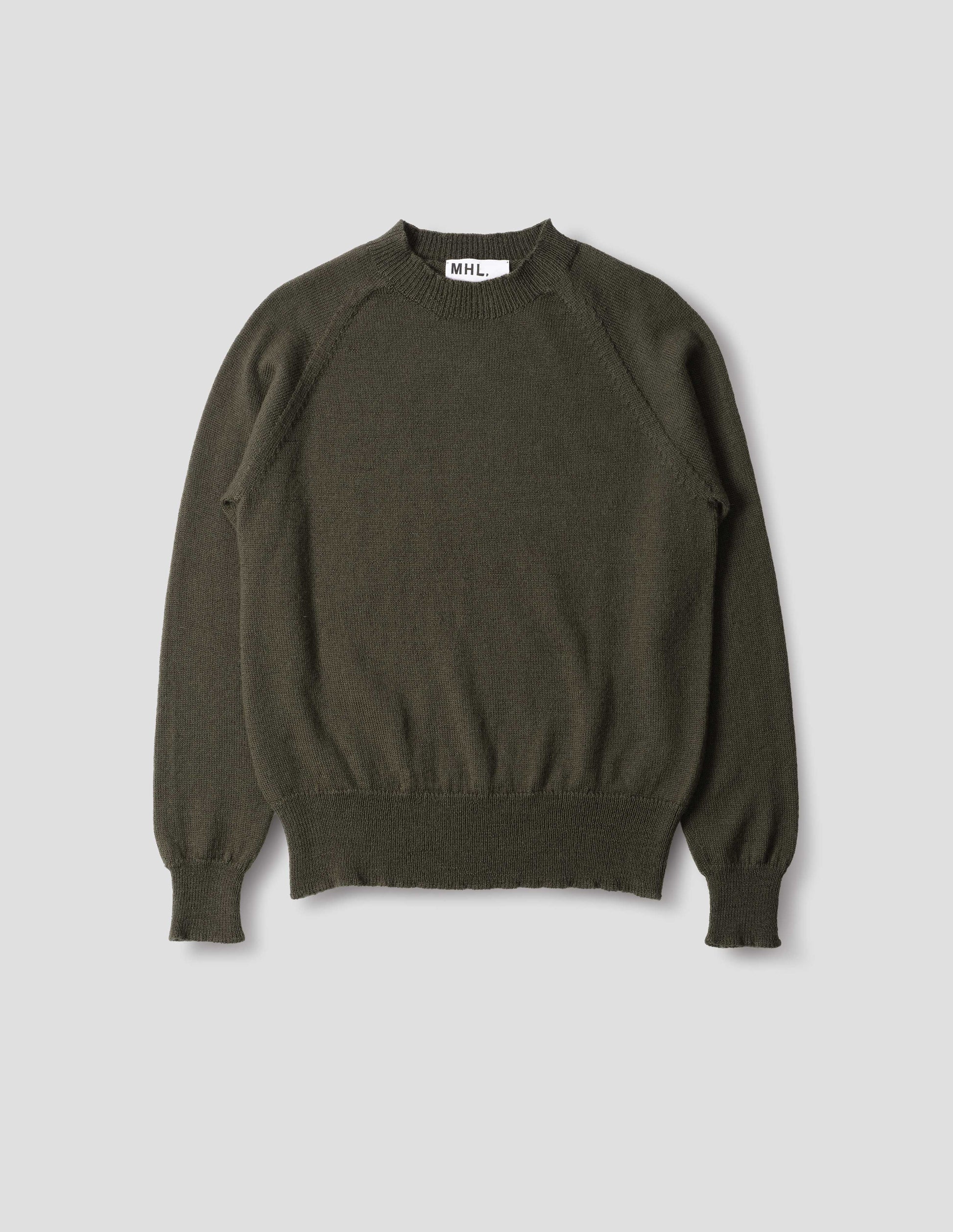 Dark green wool jumper, with raglan sleeve, rib collar, cuffs and hem, front flat lay view.