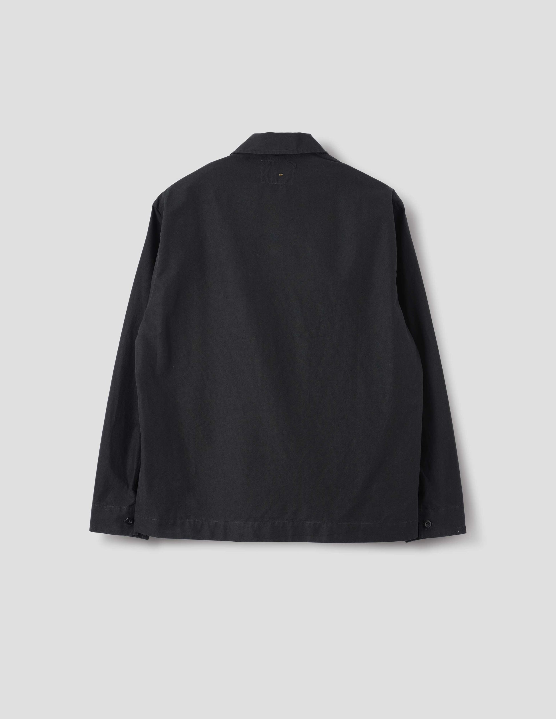 Black denim shirt, with button closure cuffs, split placket, and straight side split hem. Back flat lay view.