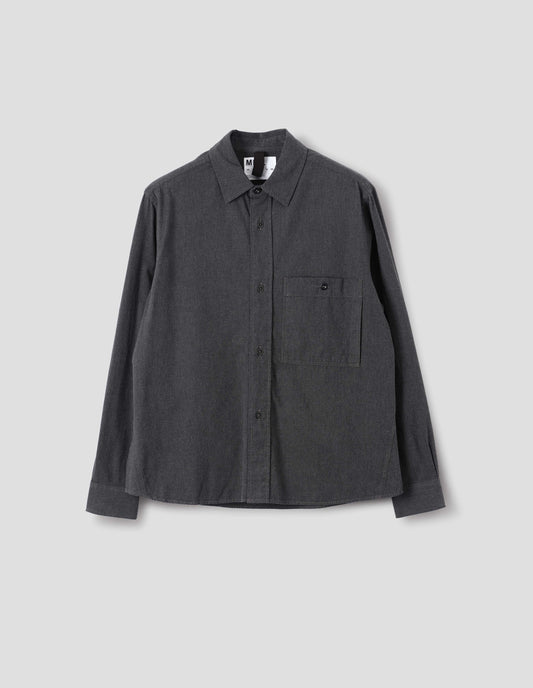 Dark grey cotton chambray shirt with a dropped shoulder, raised placket and button through chest patch pocket, front flat lay view.