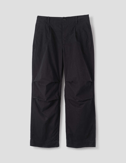 Black cotton trousers, with side seam pockets, single pleats and pleated knee detailing, front flat lay view.