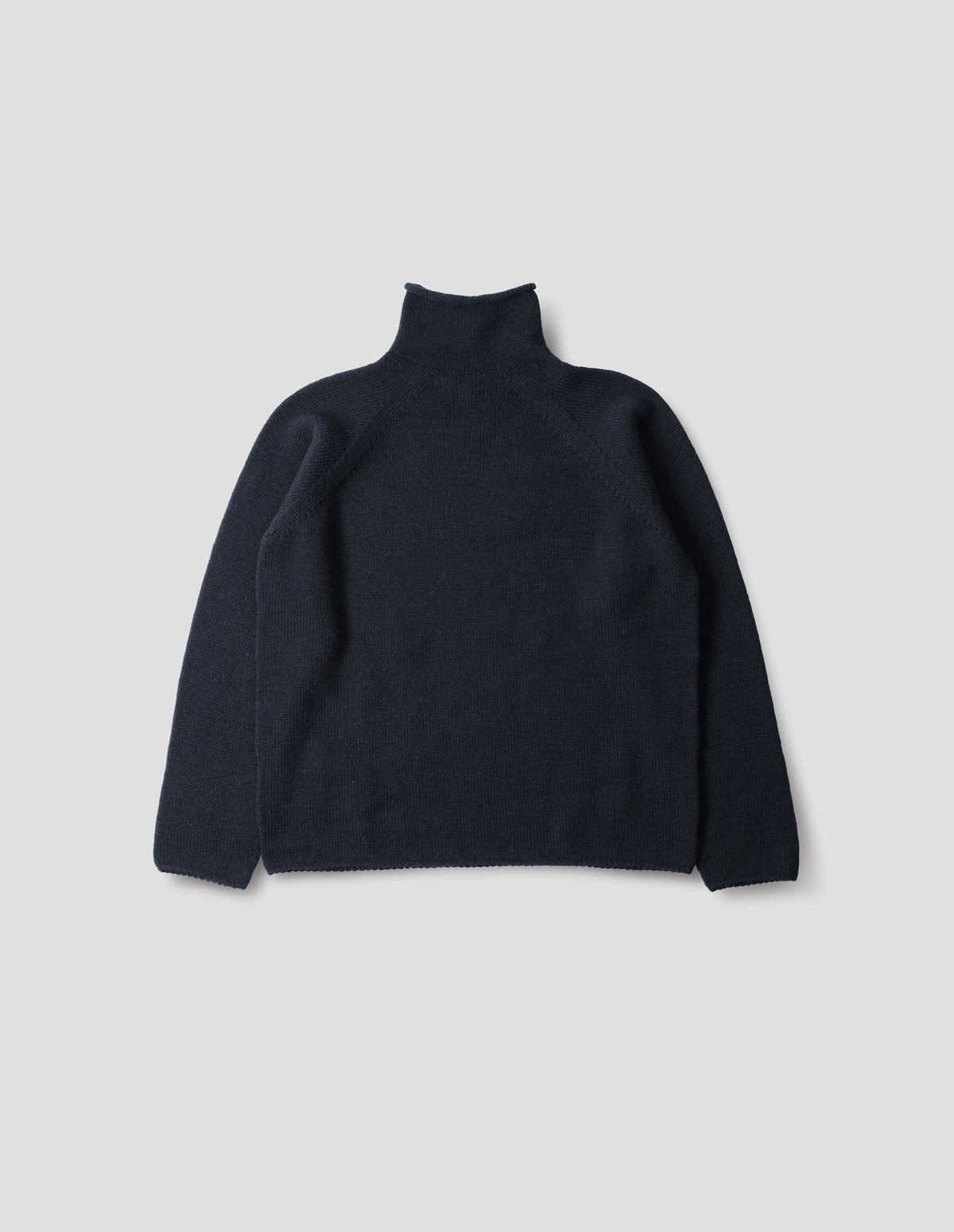 Dark blue high neck wool sweater with raglan sleeves, rolled cuffs and hem, back flat lay view.