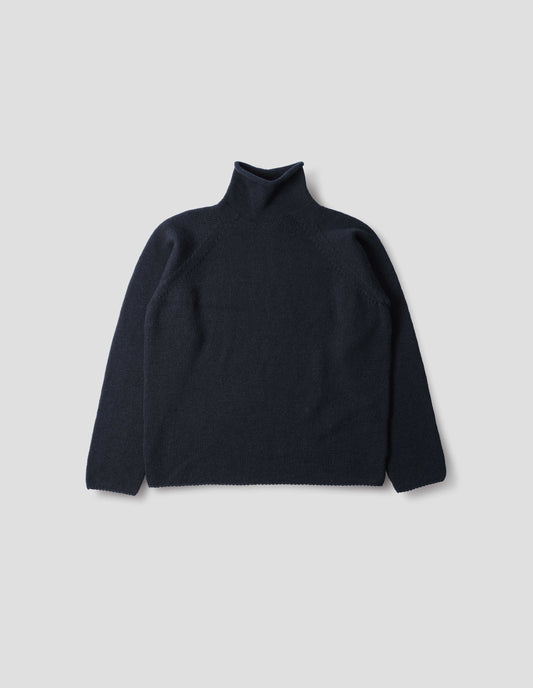 Dark blue high neck wool sweater with raglan sleeves, rolled cuffs and hem, front flat lay view.