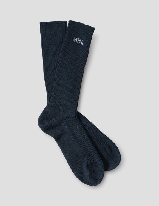 Dark blue cotton socks, with embroidered MHL logo, front flat lay view.