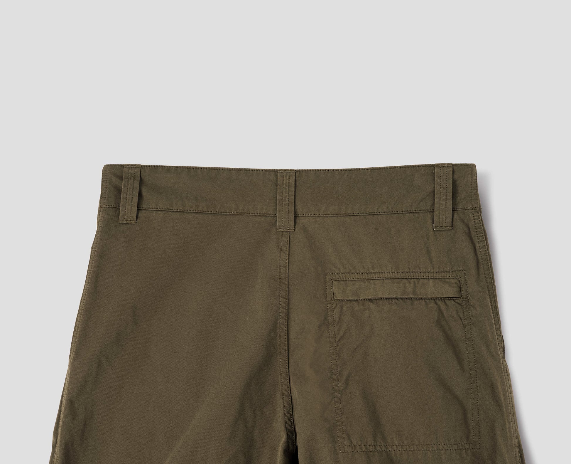 Brownish green cotton trousers with belt loops and stitch-through back pocket with concealed zip fastening, back flat lay view.
