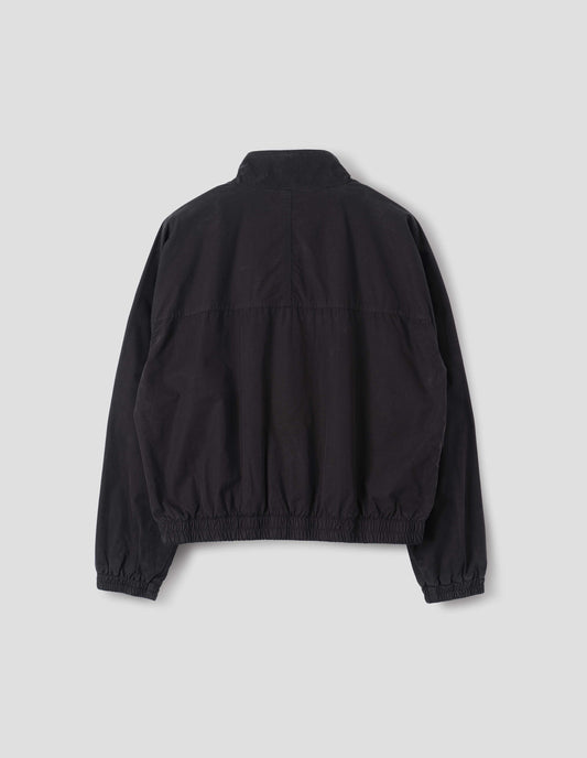 Black cotton poplin track jacket with stand collar, raglan sleeves, elasticated hem and cuffs. Back flat lay view.