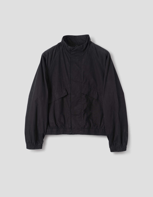 Black cotton poplin track jacket with stand collar, raglan sleeves, concealed zip closure  and press stud fastening and elasticated hem and cuffs. Large slanted front pockets. Front flat lay view. 
