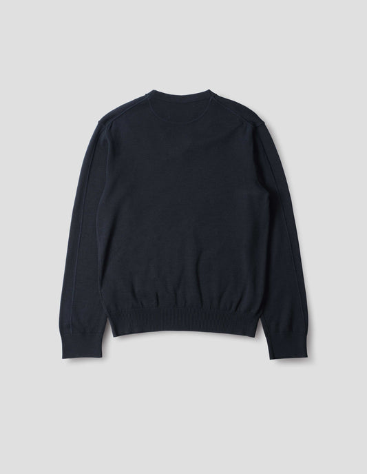 Dark navy fine wool jumper, with a half-moon yoke at the back neck, flatlock detailing on the sleeves with rib cuffs and hem, back flat lay view.