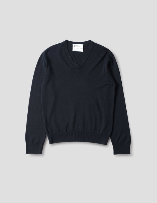 Dark navy fine wool jumper with v neck, flatlock detailing on the sleeves, and laid-on neck trim, cast-off edge details at the neckline with rib cuffs and hem, front flat lay view.