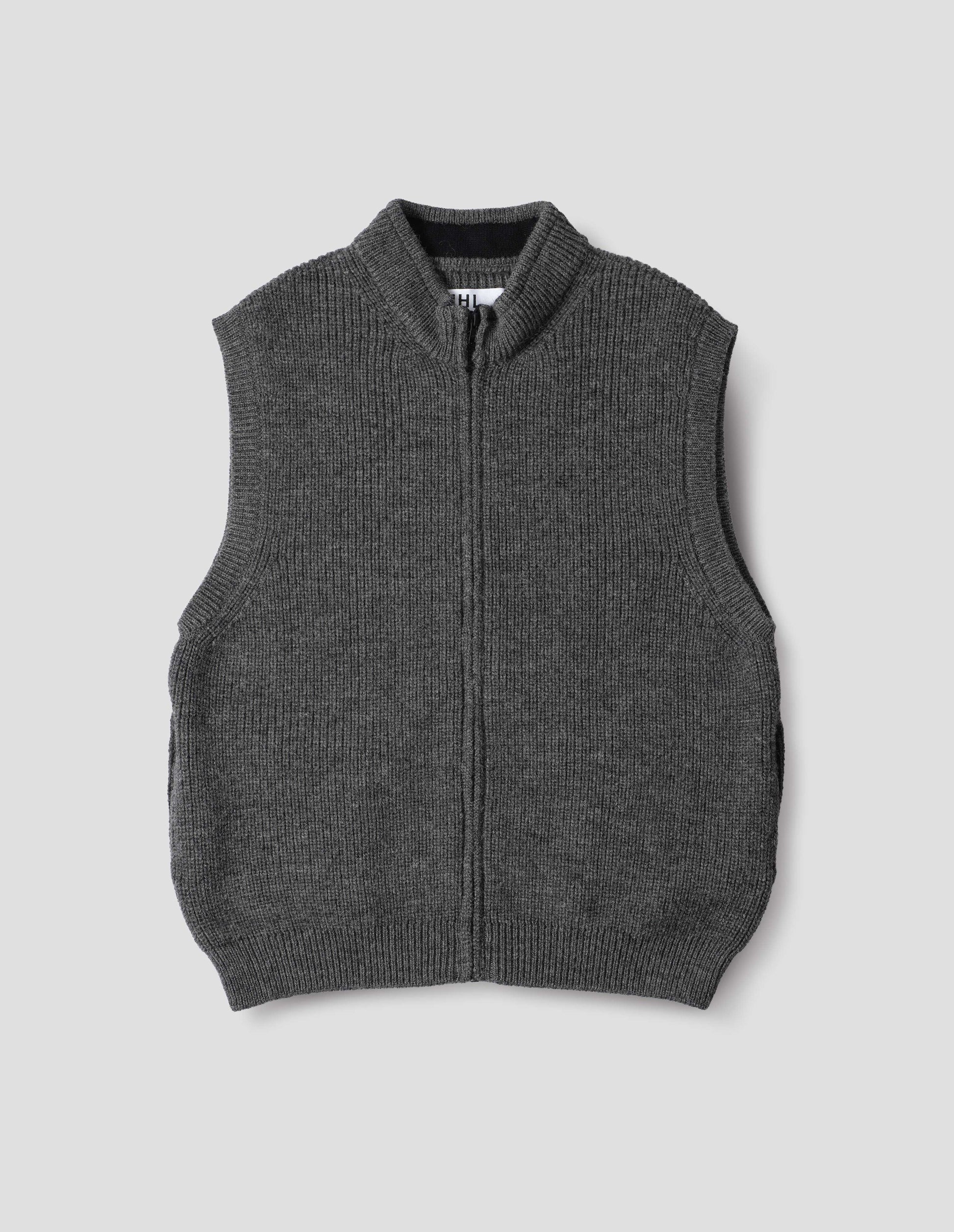 Grey knitted wool sleeveless gilet, with rib neck, armholes and hem, and a Vislon zip. Front flat lay view.