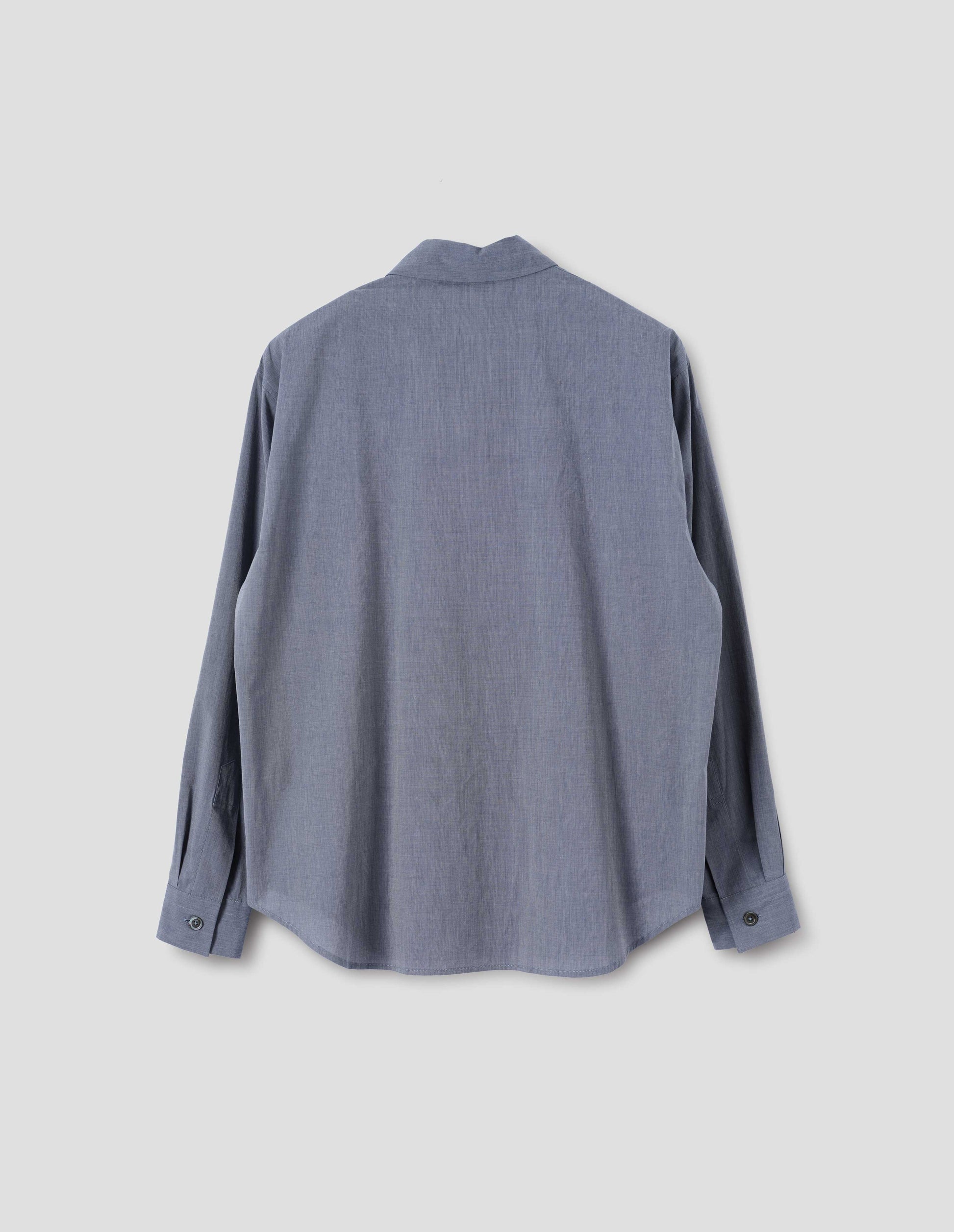 Blue cotton shirt with mother of pearl buttons on cuffs and curved hem. Back flat lay view.