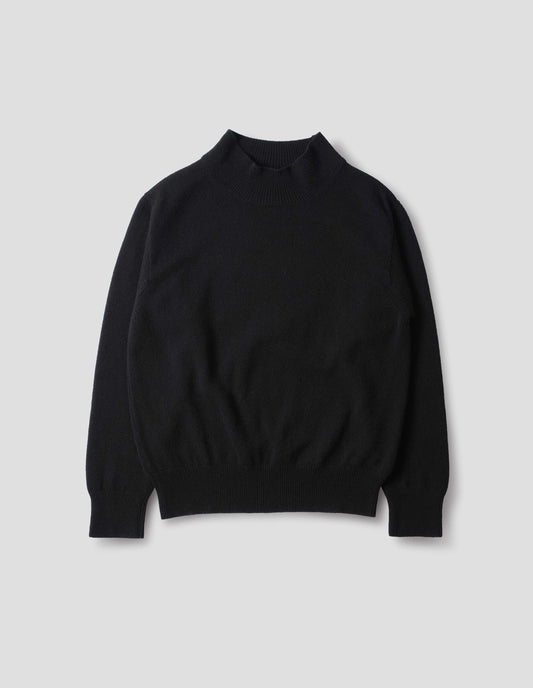Black fully fashioned seamless wool jumper with rib mock neck, set-in sleeves, and ribbed cuffs and hem. Front flat lay view.