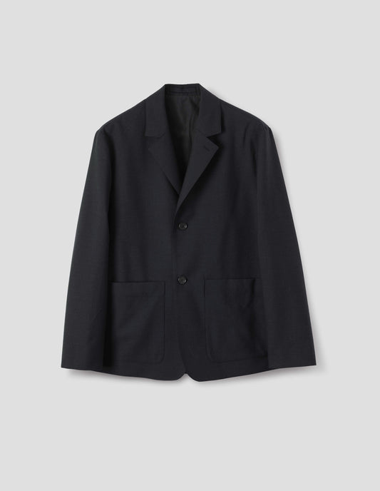 Black wool blazer with dropped shoulders, horn buttons and deep patch pockets. Front flat lay view.
