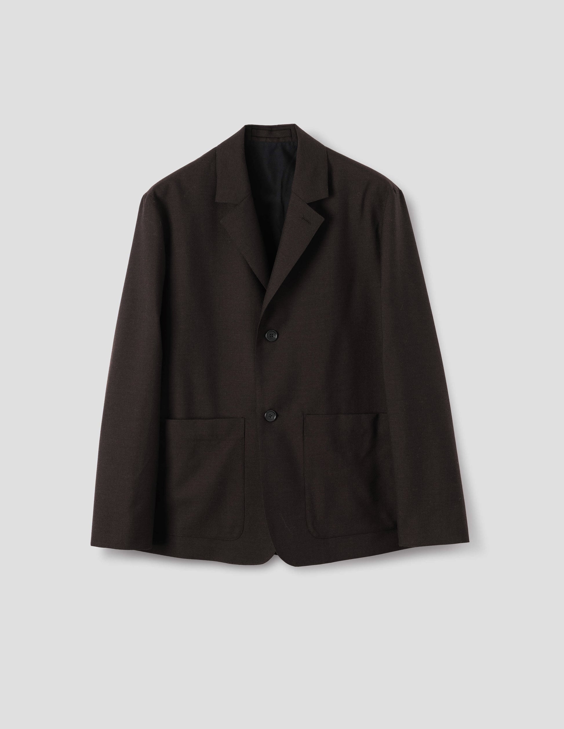 Dark brown wool blazer with dropped shoulders, horn buttons and deep patch pockets. Front flat lay view.