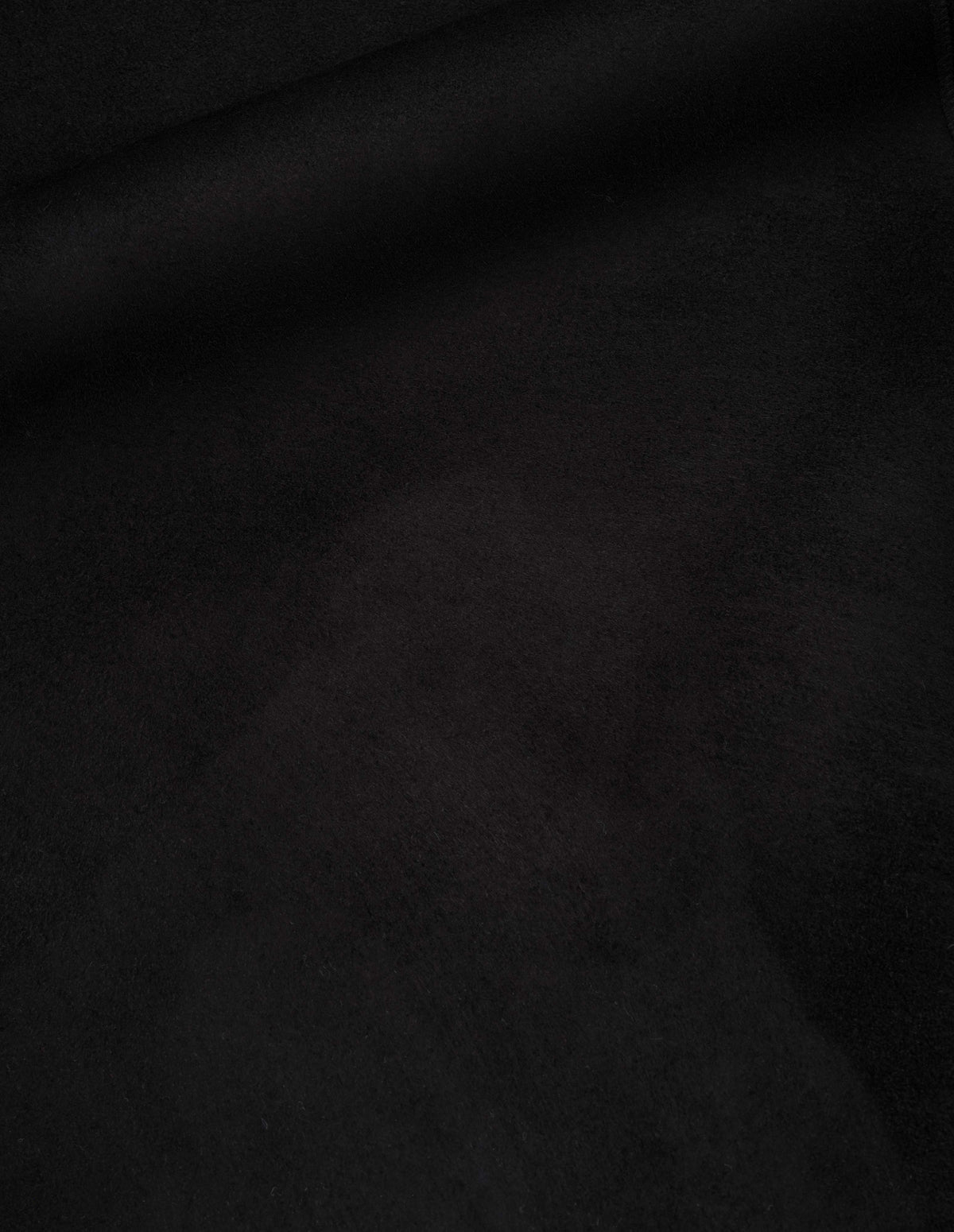 Black curly merino shearling coat fabric swatch.